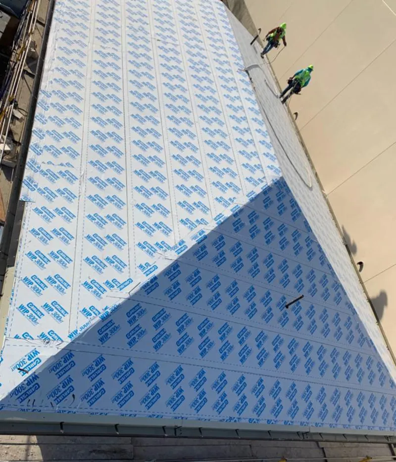 Professional roofers installing underlayment on a metal roof in Matawan